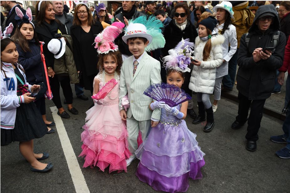 Children show off their Easter finery as a crowd looks on. 