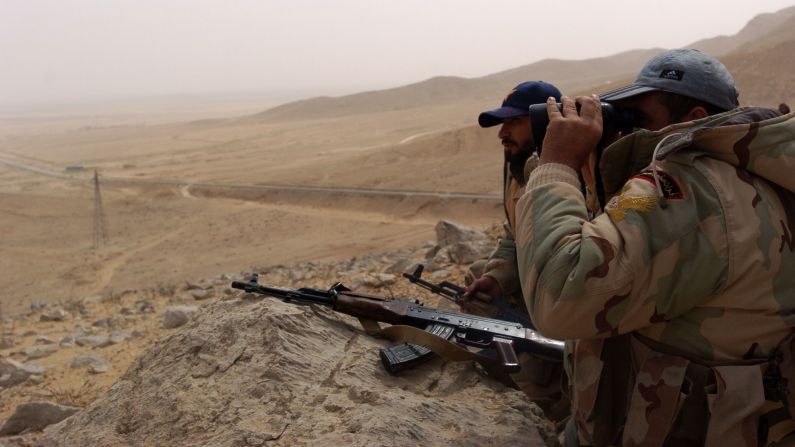 Syrian troops monitor the surrounding area from their location on the outskirts of Palmyra on March 24.
