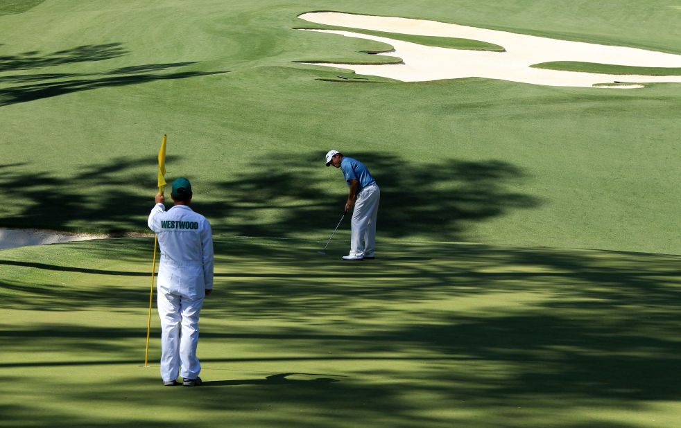 Foster tends the flag while Westwood putts  on the 10th green during the second round of the 2010 Masters. Westwood led going into the final round that year but eventually had to settle for second place behind winner Phil Mickelson. 