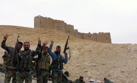 Syrian pro-government forces gesture next to the Palmyra citadel.