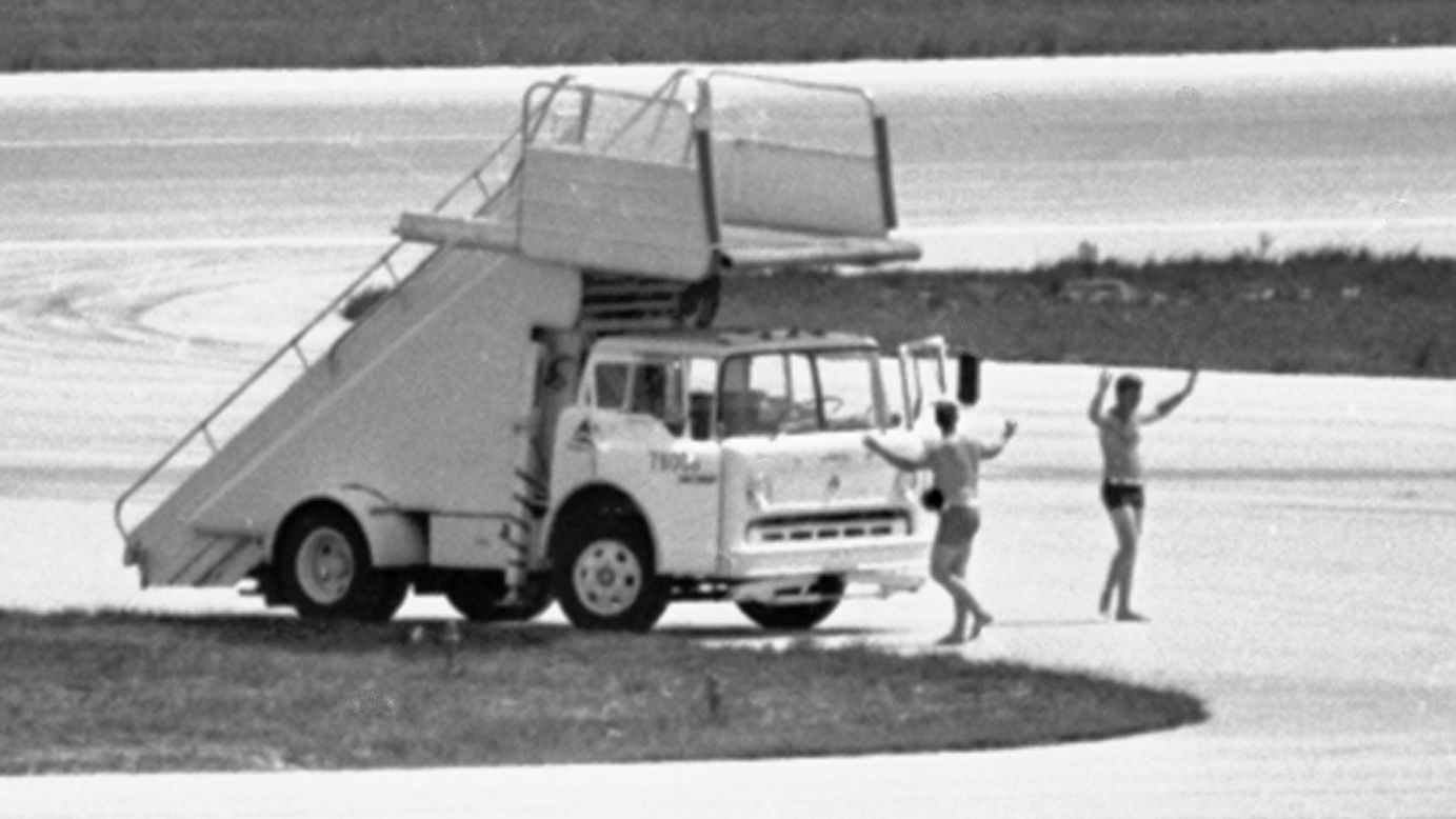 In this July 1972 photo, FBI agents in Miami, wearing only swim trunks, per a hijacker's instructions, prepare to deliver a case containing a $1 million ransom to a hijacked Delta DC-8 jet.