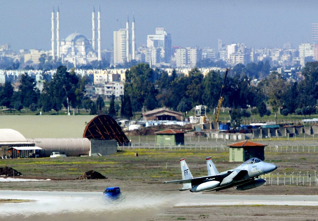 An F-15 fighter jet glides in for a landing in front of Adana's main mosque March 7, 2003 at Incirlik Air Force Base in Turkey.