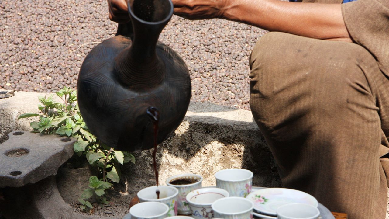 At a local forest homestead a woman makes coffee using a jebena clay pot, the traditional method.