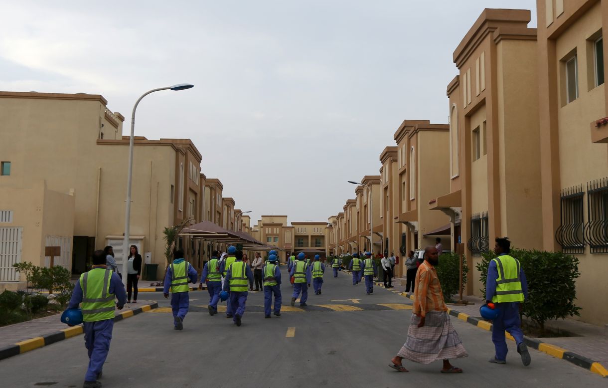Foreign laborers working on the construction site of the al-Wakrah football stadium, one of Qatar's World Cup venues, walk back to their accommodation compound after a working day in May 2015.