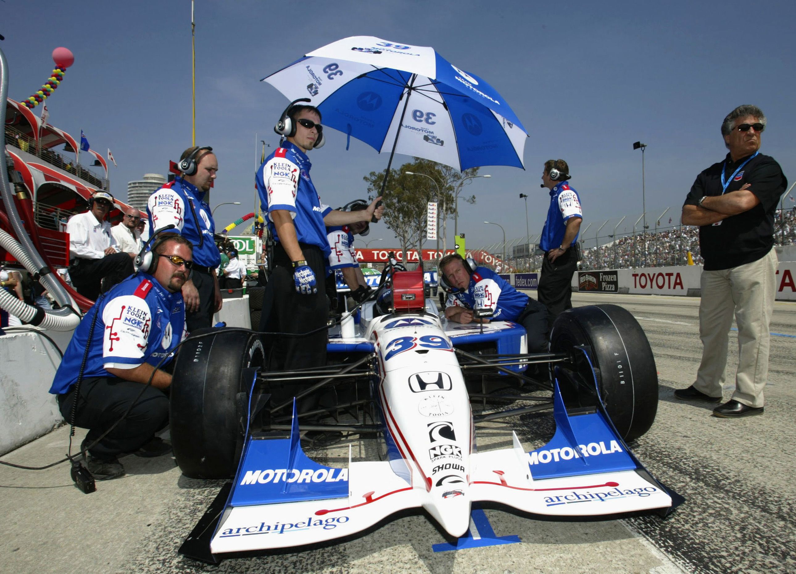 Andretti looks on as son Michael prepares for the 2002 IndyCar Long Beach Grand Prix, a race Michael would go on to win, just like his Dad. Michael Andretti is now president of the Andretti Formula E team.