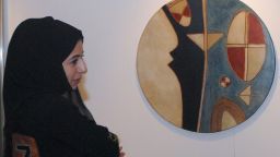 An Emirati woman is seen next to an art work by Farid Belkahia of Morocco prior to Christie's first public Modern and Contemporary art sale in the Middle East in 2006.