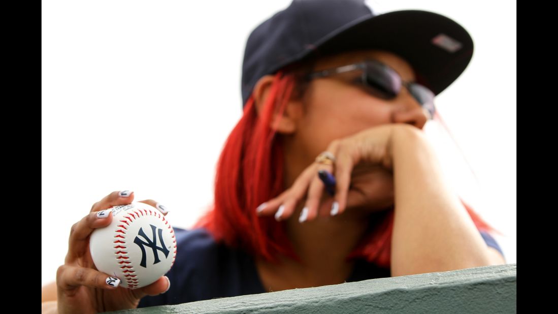 A New York Yankees fan holds an autograph ball over the dugout wall during a spring-training game in Jupiter, Florida, on March 8.