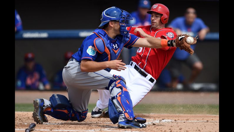 Washington's Scott Sizemore slides safely into home, beating a tag by New York Mets catcher Travis d'Arnaud during a game in Viera, Florida, on March 11.