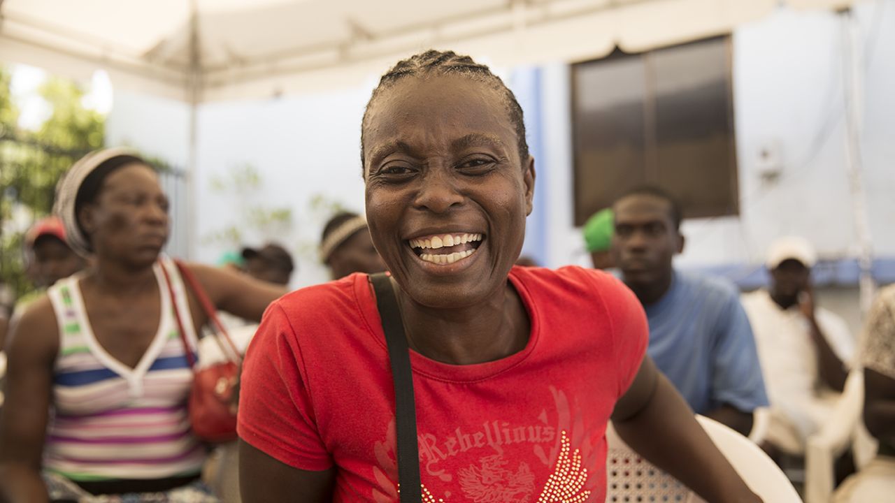 Mirlande Saint Jean waits to get her national ID card after sleeping in line on the sidewalk.
