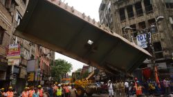 Workers work on April 1 to remove a section of the collapsed overpass.