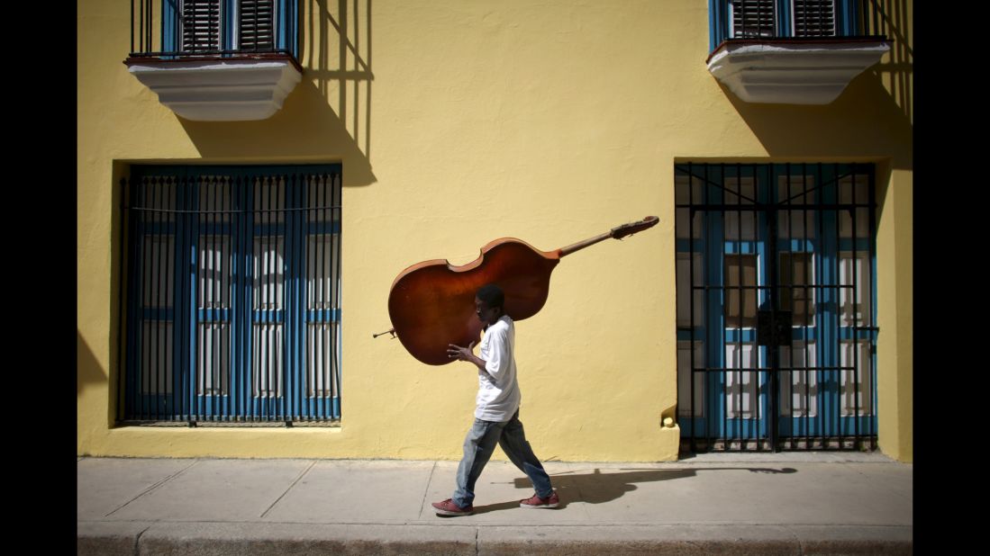 Musician Frilal Ortiz carries a double bass through downtown Havana. In March, Barack Obama became the first U.S. president to visit Cuba since Calvin Coolidge stopped by in 1928. 