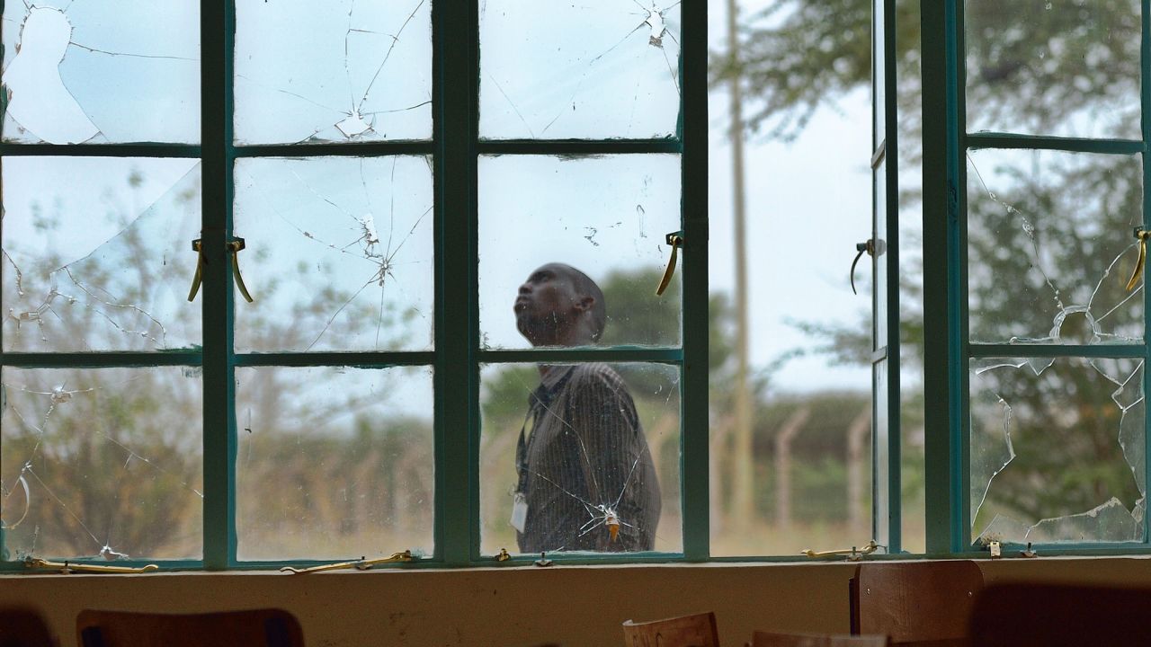 A man walks outside a lecture hall with bullet-shattered windowpanes. During the 2015 attack, the gunmen stormed in at dawn, separated Muslims and shot Christians to death. In some cases, the militants forced students to call relatives to listen in during the killings.<br />