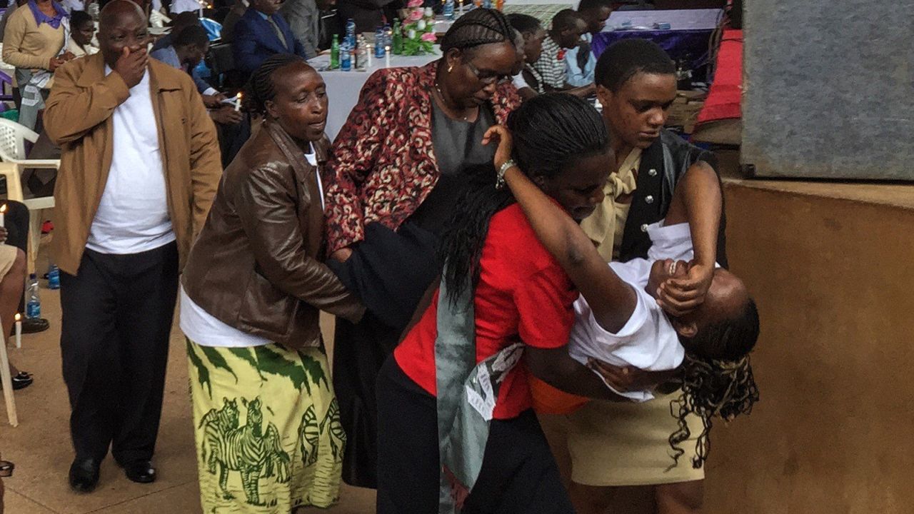 A student collapses and is carried out crying from a ceremony Saturday marking the attack anniversary.