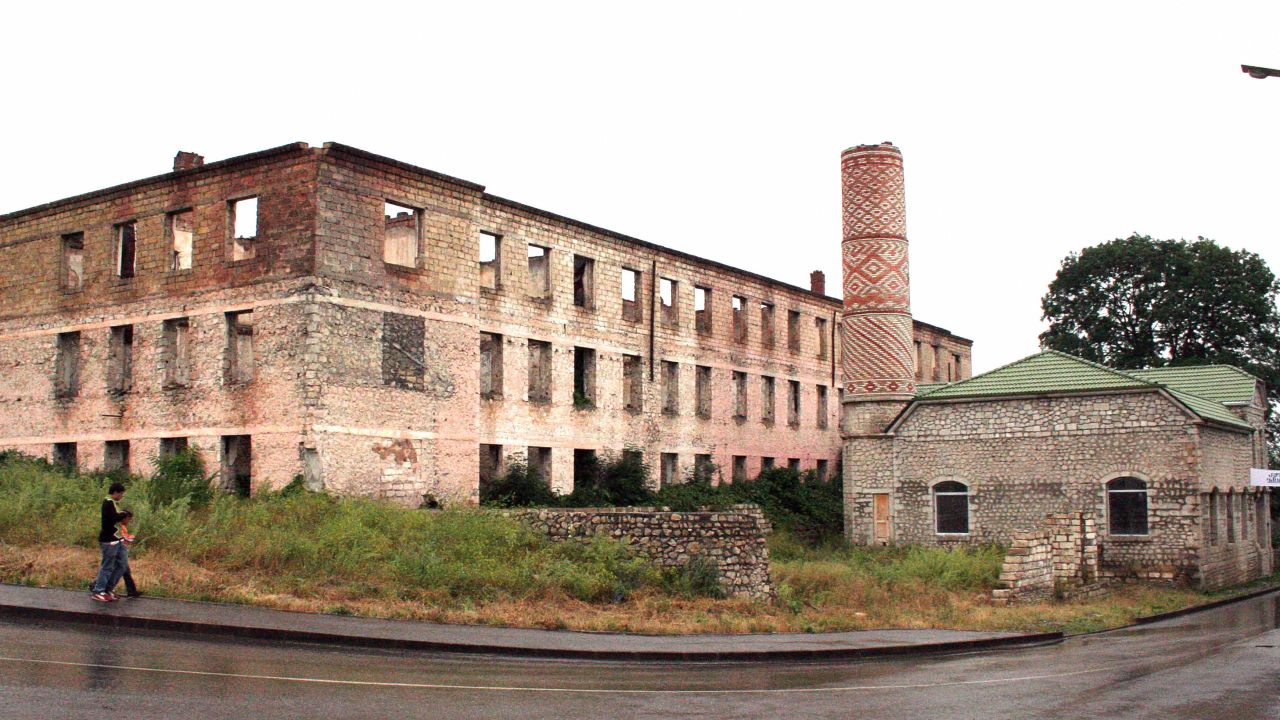Residents pass the ruins of a building and a mosque in Shusha, Nagorny Karabakh, in July 2007.