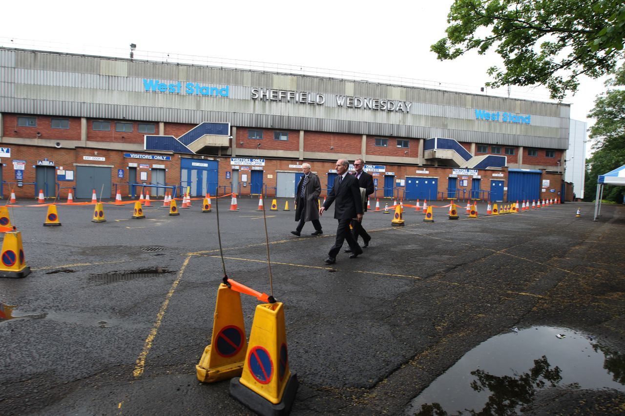 Coroner Lord Justice Goldring (centre) walks outside the Leppings Lane stand at Hillsborough as jurors examine the scene of the disaster. The cones show the layout of the area outside the ground as it had been in 1989.
