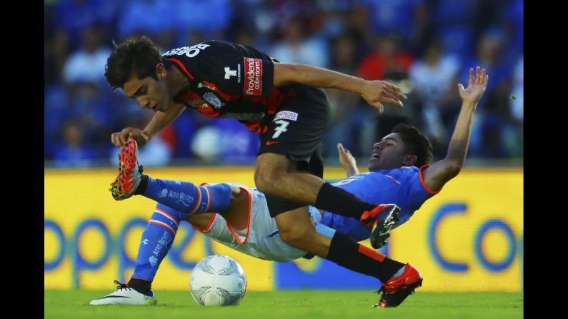 Cruz Azul's Kevin Montano slides into Pachuca's Rodolfo Pizarro during a league match in Mexico City on Saturday, April 2.