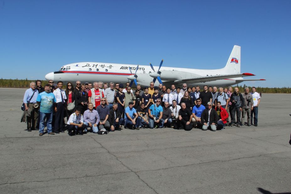 Members of Juche's 2014 tour stand in front of an Ilyushin IL-18 at North Korea's Samjiyon Airport in Ryanggang province.