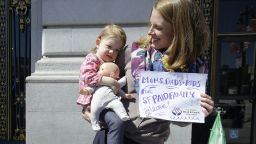 Kim Turner holds her daughter Adelaide Turner Winn before a rally supporting paid family leave at City Hall in San Francisco on April 5. 