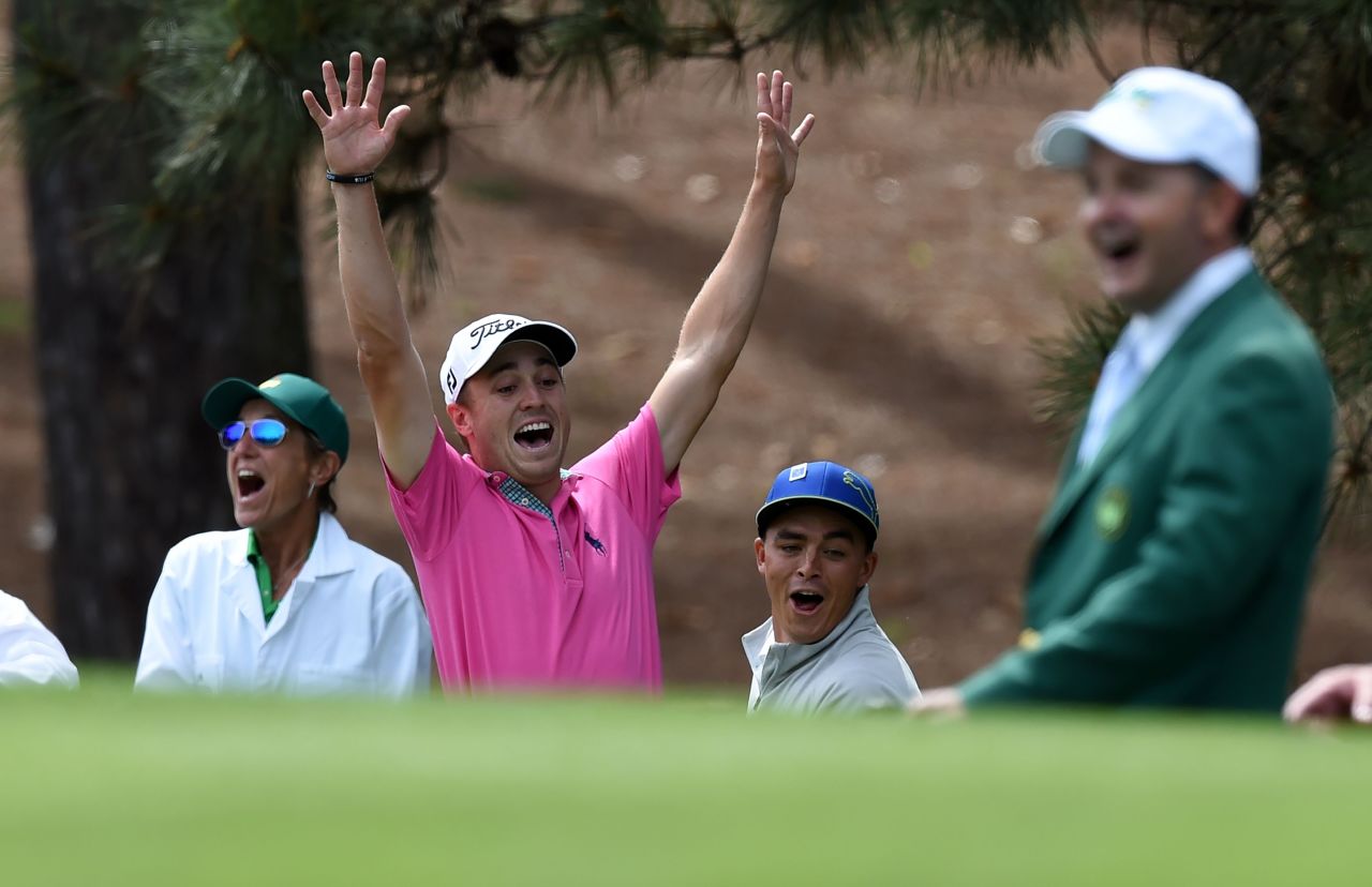 U.S. golfer Justin Thomas (C) celebrates with Rickie Fowler after shooting a hole-in-one at the fourth... 