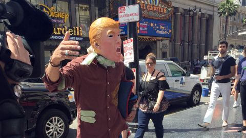 A Trump look-alike seeks cash tips in exchange for posing with tourists because "this Donald is broke."