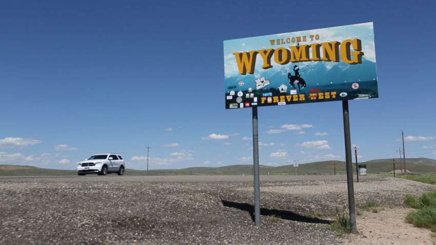 A "Welcome to Wyoming" sign along a highway at the Utah-Wyoming border.