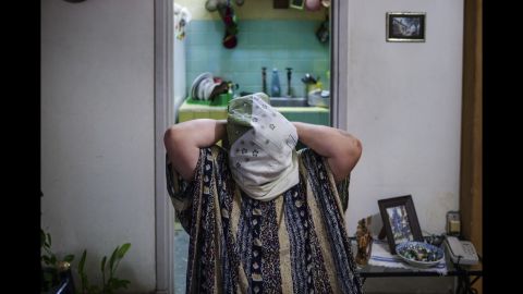 A 72-year-old woman named Shahira struggles with an Islamic scarf. She was an active Christian until three years ago. Now she is member of the Cuban Islamic Committee for Women.