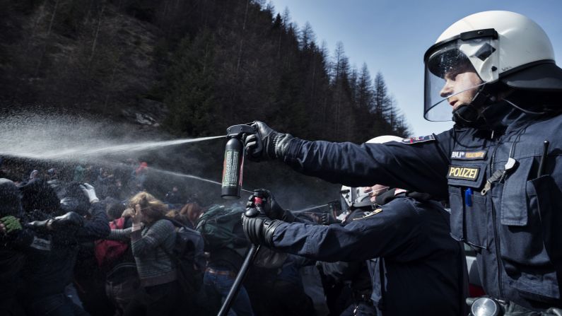 An Austrian police officer uses pepper spray to ward off protesters after violence broke out at a pro-immigration rally near the Italian border on Sunday, April 3. 