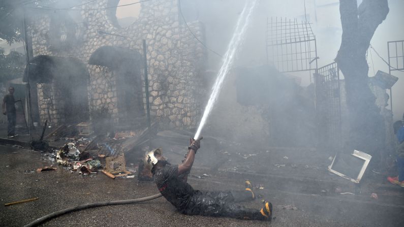 A firefighter works in Port-au-Prince, Haiti, where a hotel, a house and several small shops were destroyed on Monday, April 4. 