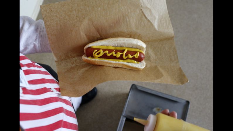 A vendor displays a hot dog with "Orioles" written in mustard before an Opening Day baseball game between the Baltimore Orioles and the Minnesota Twins on Monday, April 4.