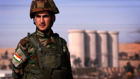 An Iraqi Kurdish Peshmerga soldier stands guard near the Mosul Dam on the Tigris River.