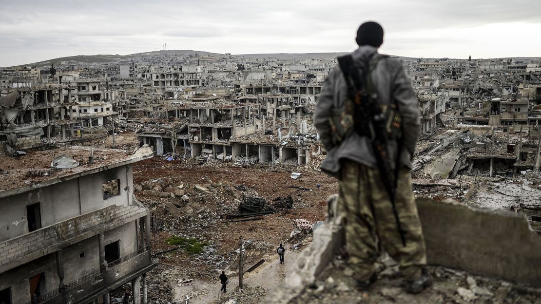 A Kurdish marksman stands atop a building as he looks at the destroyed Syrian town of Kobani on January 30, 2015. Kurdish forces recaptured the town on the Turkish frontier on January 26, in a symbolic blow to the jihadists who have seized large swathes of territory in their onslaught across Syria and Iraq.