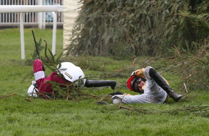 Jockeys Nina Carberry and  P.W Mullins lie on the ground after falling from their mounts at The Chair fence -- an occupational hazard in the race business.