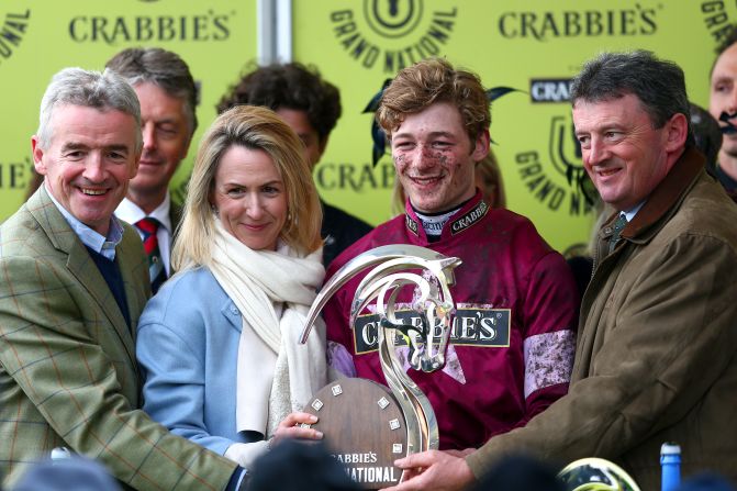 Mullins (2nd R) poses with the race trophy next to horse owner and Ryanair boss, Michael O'Leary (L), and his wife, Anita O'Leary (2nd L), in the winners' enclosure.