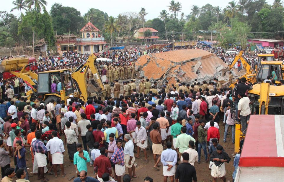 People gather at the site of the explosion and roof collapse as workers go through the debris looking for victims. 