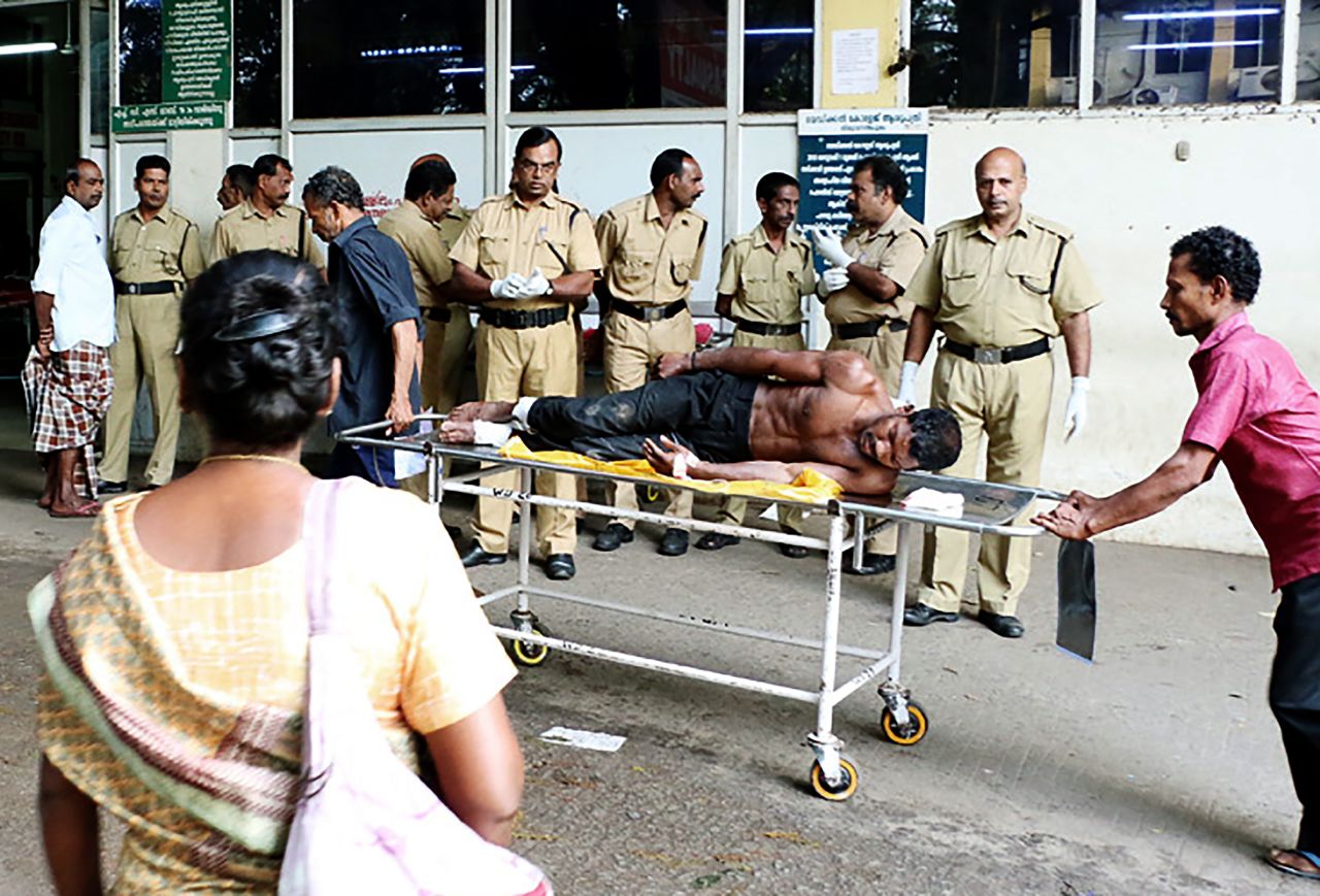 Indian medical officials transport an injured man from a vehicle into a hospital in Paravur, India. 