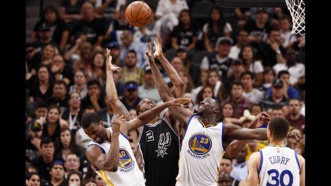 San Antonio's Kawhi Leonard, center, battles for a rebound with Golden State's Harrison Barnes, left, and Draymond Green during an NBA game in San Antonio on Sunday, April 10. Golden State won the game 92-86, tying the all-time NBA record for wins in a season.