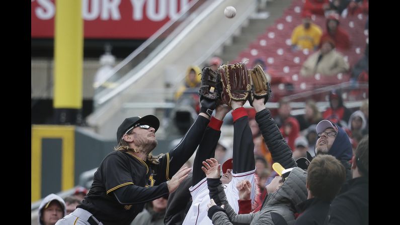Pittsburgh first baseman John Jaso, left, reaches for a foul ball during a game in Cincinnati on Saturday, April 9. He was unable to make the diving catch, but he <a href="index.php?page=&url=http%3A%2F%2Fm.mlb.com%2Fcutfour%2F2016%2F04%2F09%2F171379814" target="_blank" target="_blank">helped up a fan</a> he knocked over on the attempt.