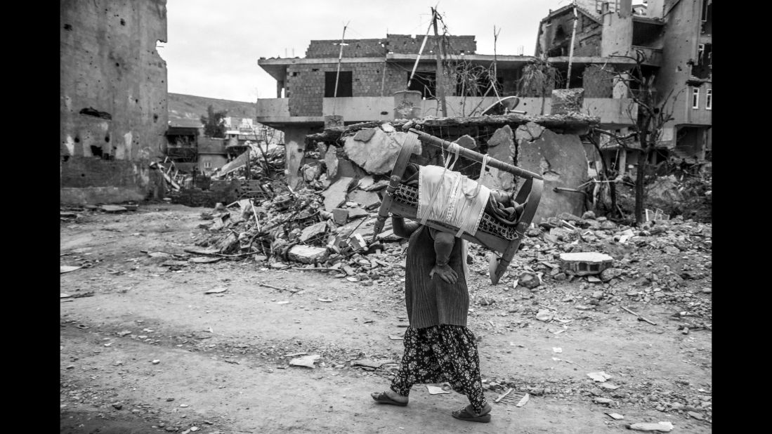 A woman carries her baby in the ruins of Cizre, Turkey, in March. "What I witnessed there was unforgettable," photographer Emin Ozmen said. "I was really shocked to see this kind of scene in my country: 40% of the city was totally destroyed during the clashes."