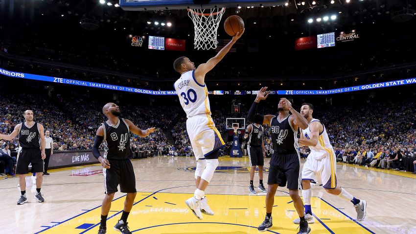 Stephen Curry #30 of the Golden State Warriors goes up to score on a reverse layup against the San Antonio Spurs in the third quarter of an NBA Basketball game at ORACLE Arena on April 7, 2016 in Oakland, California.