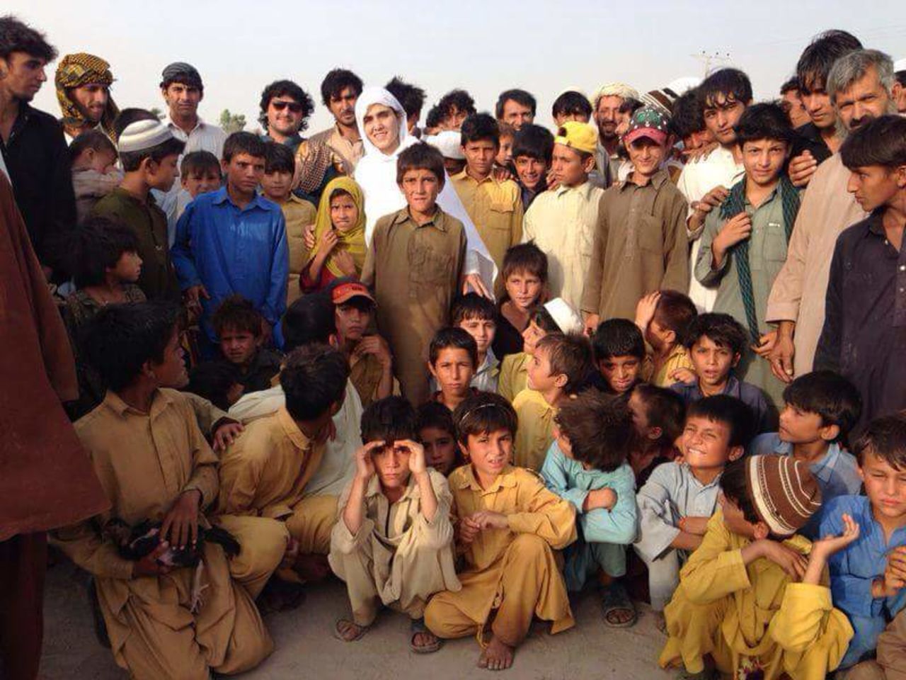 Maria Toorpakai standing among Pashtun children evacuated from their tribal land due to tensions between the army and extremist factions. She organized a special squash event in Islamabad that brought all the displaced children over in hired buses. 
