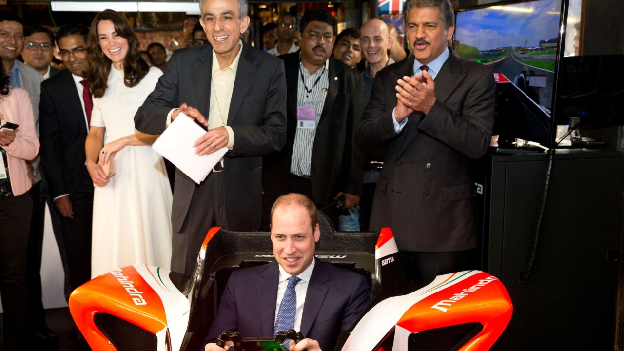 Prince William flies in a Formula E simulator in India, watched by his wife Catherine, Duchess of Cambridge.