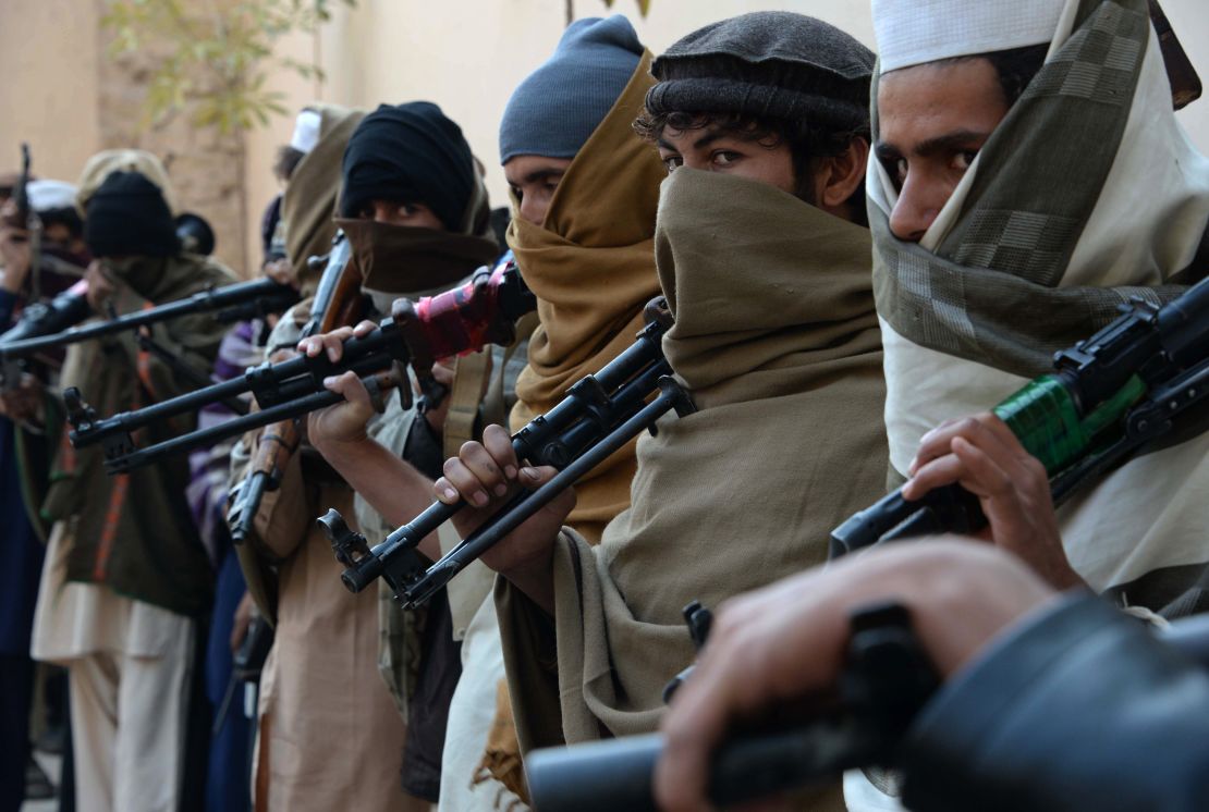 Former Taliban fighters hold weapons they plan to return in a 2015 reconciliation event in Jalalabad, Afghanistan.