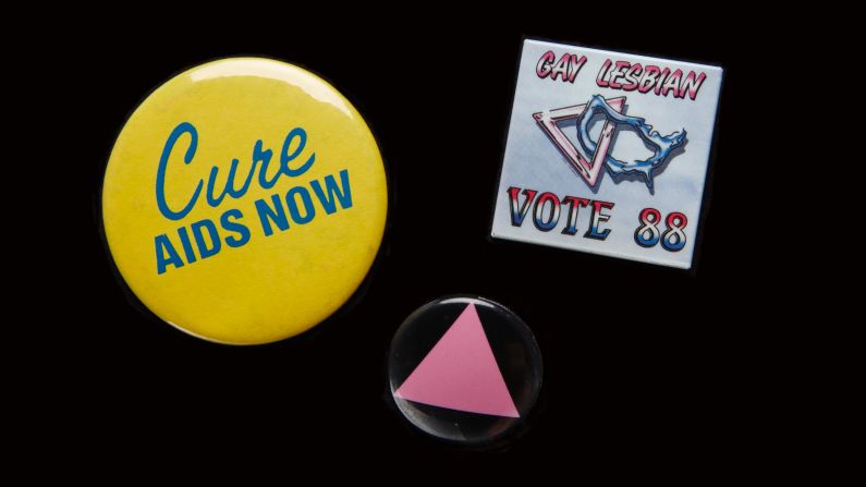 The AIDS epidemic moved many people out of the closet and into the streets to fight for greater acceptance. Pins were an easy way to signal support. The pink triangle honored LGBT victims of the Holocaust and was a "reminder of the Holocaust perpetrated by our governments refusing to deal with AIDS," said <a href="index.php?page=&url=https%3A%2F%2Fbooks.google.com%2Fbooks%3Fid%3Dd5_rAgAAQBAJ%26pg%3DPA585%26lpg%3DPA585%26dq%3Dthe%2Btime%2Bis%2Bnot%2Bright%2Bto%2Bmarch%2Bon%2Bwashington%2Bcathy%2Bwoolard%26source%3Dbl%26ots%3D9SqK4h_lMo%26sig%3DbEE1unMopqyn6ibfXFN1eyJxKDk%26hl%3Den%26sa%3DX%26ved%3D0ahUKEwiigpGkrvjLAhXLQyYKHZgbAc0Q6AEIHDAA%23v%3Donepage%26q%3Dthe%2520time%2520is%2520not%2520right%2520to%2520march%2520on%2520washington%2520cathy%2520woolard%26f%3Dfalse" target="_blank" target="_blank">Cathy Woolard in 1989.</a> Woolard, an Atlanta LGBT organizer, went on to be the Atlanta City Council's first female president. The buttons belonged to <a href="index.php?page=&url=http%3A%2F%2Femorymedicinemagazine.emory.edu%2Fissues%2F2015%2Ffall%2Ffeatures%2Faging-with-hiv%2Findex.html%23RHODES" target="_blank" target="_blank">Richard Rhodes</a>, a Navy veteran and community organizer who became the first known gay candidate to run for the Georgia House in 1988, and was the first known gay delegate to the Democratic National Convention from Georgia. Every year on his birthday he would get an HIV test. AT 65, he tested HIV-positive. He remains an activist and an advocate for HIV testing. 