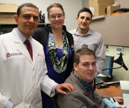 Patient Ian Burkhart, seated, poses with members of his research team during a neural bypass training session.