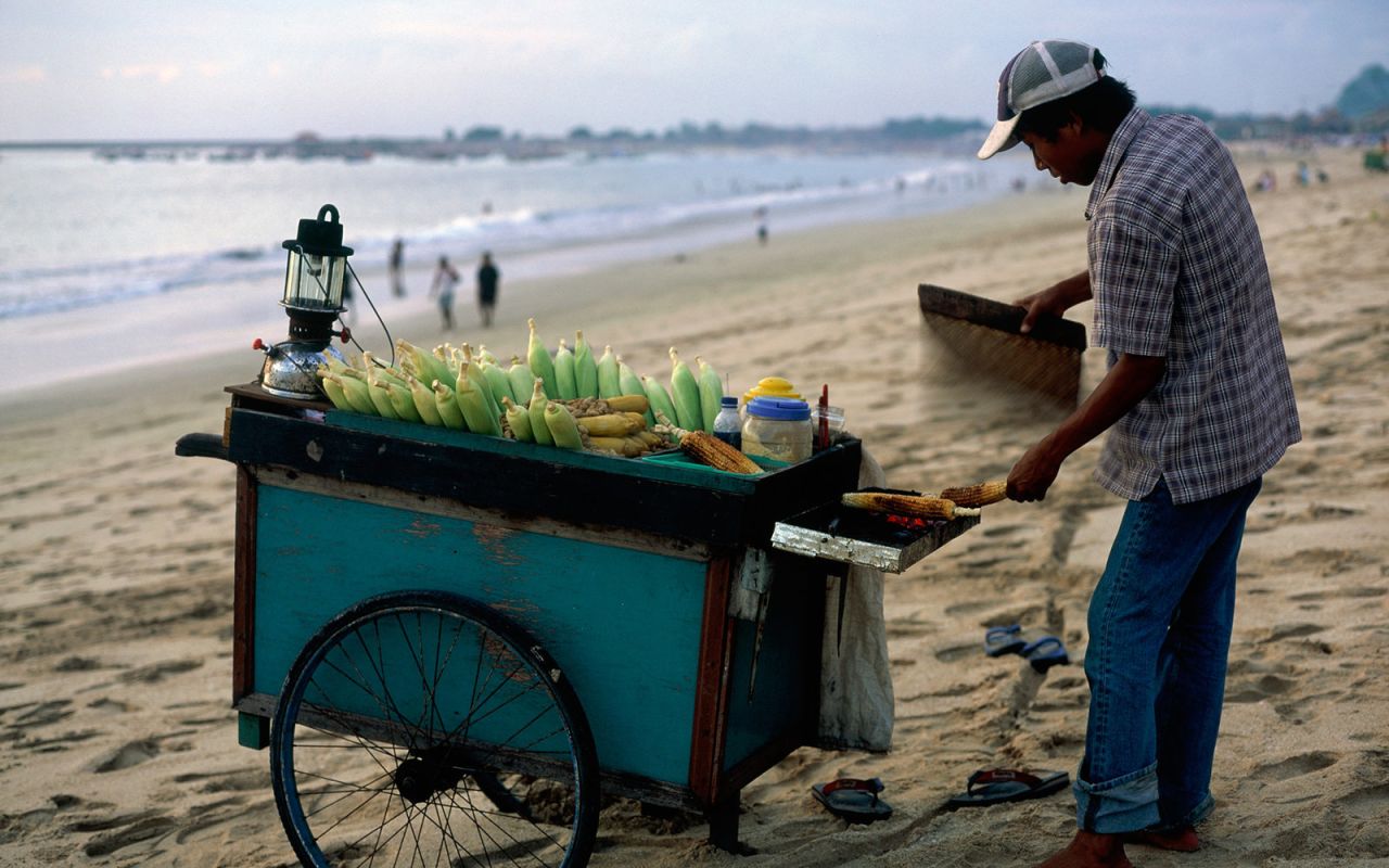 <strong>Jimbaran Beach:</strong> Jimbaran Beach sits on Bali's southwestern coast, where the mainland connects to the Bukit Peninsula. It's home to luxury resorts like the Four Seasons and the Intercontinental. Restaurants line the shore with tables on the sand.