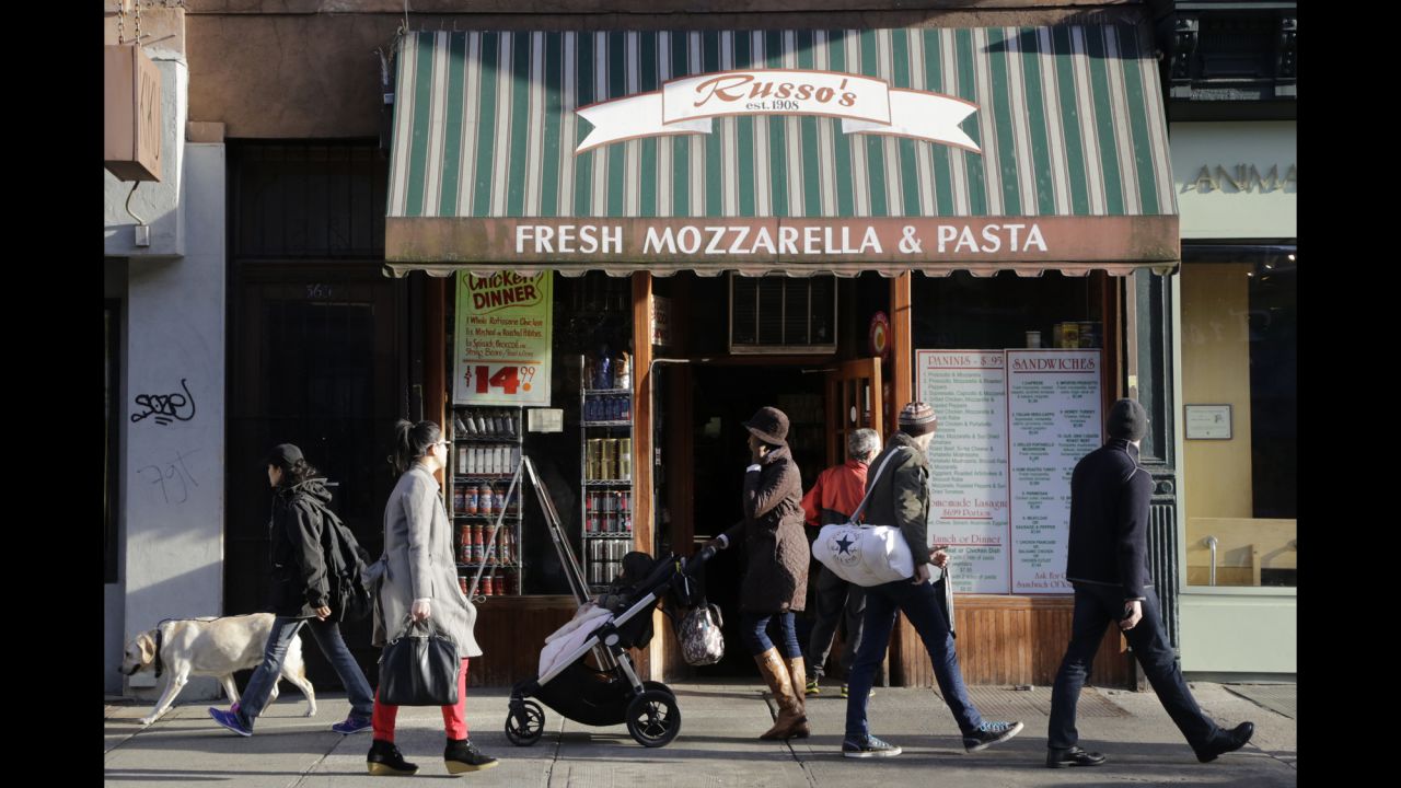 People stroll past an Italian food shop in the Park Slope neighborhood in Brooklyn, where  New York Mayor Bill de Blasio lived before his election. 