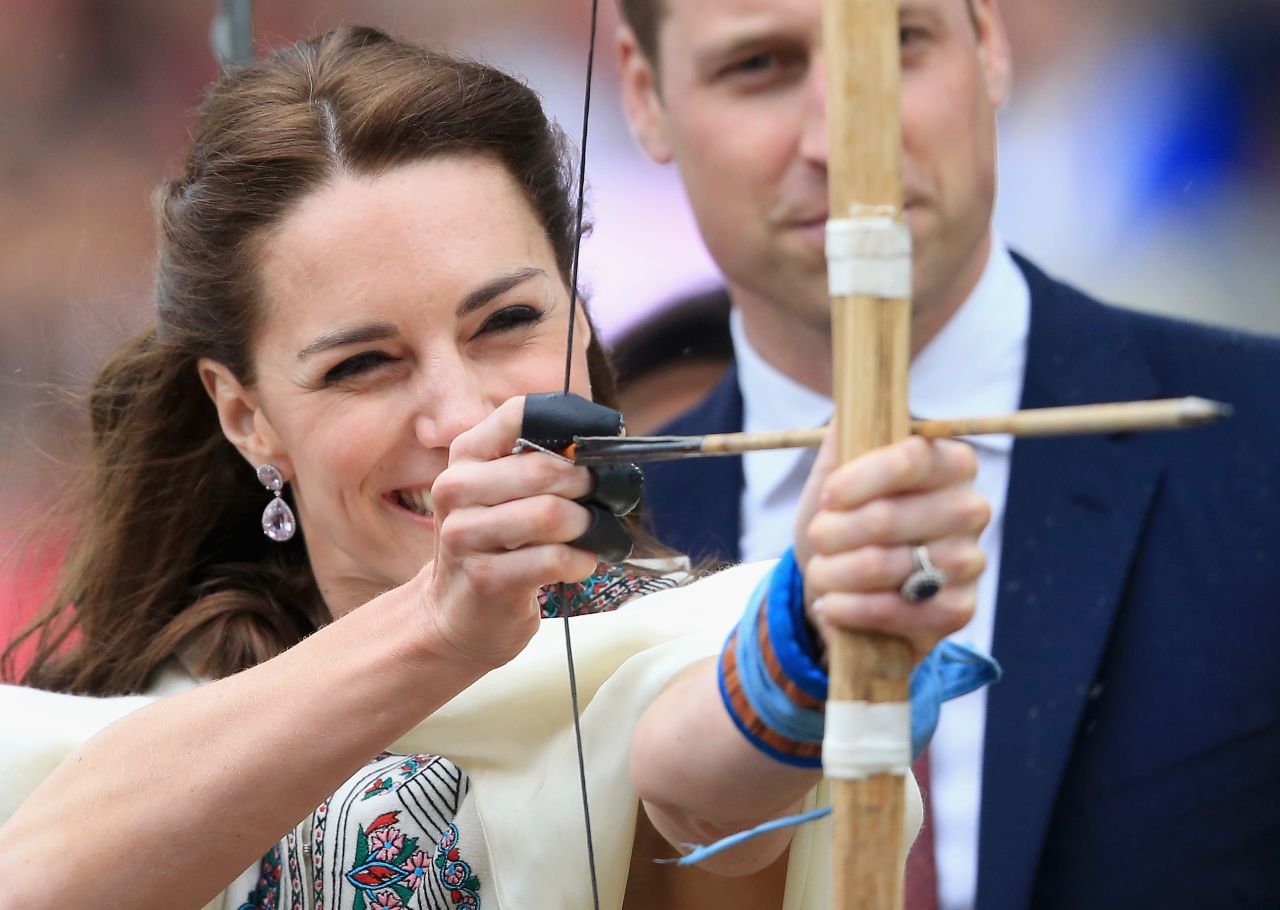 Prince William watches as his wife fires an arrow during an archery demonstration in Paro, Bhutan, on April 14.