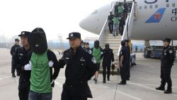In this photo released by Xinhua News Agency, Chinese suspects involved in wire fraud are escorted off a plane upon arriving at the Beijing Capital International Airport in Beijing on Wednesday, April 13, 2016. The deportation of nearly four dozen Taiwanese that's part of a larger group including mainland Chinese from Kenya to China where they are being investigated over wire fraud allegations is focusing new attention on Beijingís willingness to assert its sovereignty claim over the Taiwan, and the leverage it wields over smaller nations in backing that position.(Yin Gang/Xinhua News Agency via AP) NO SALES