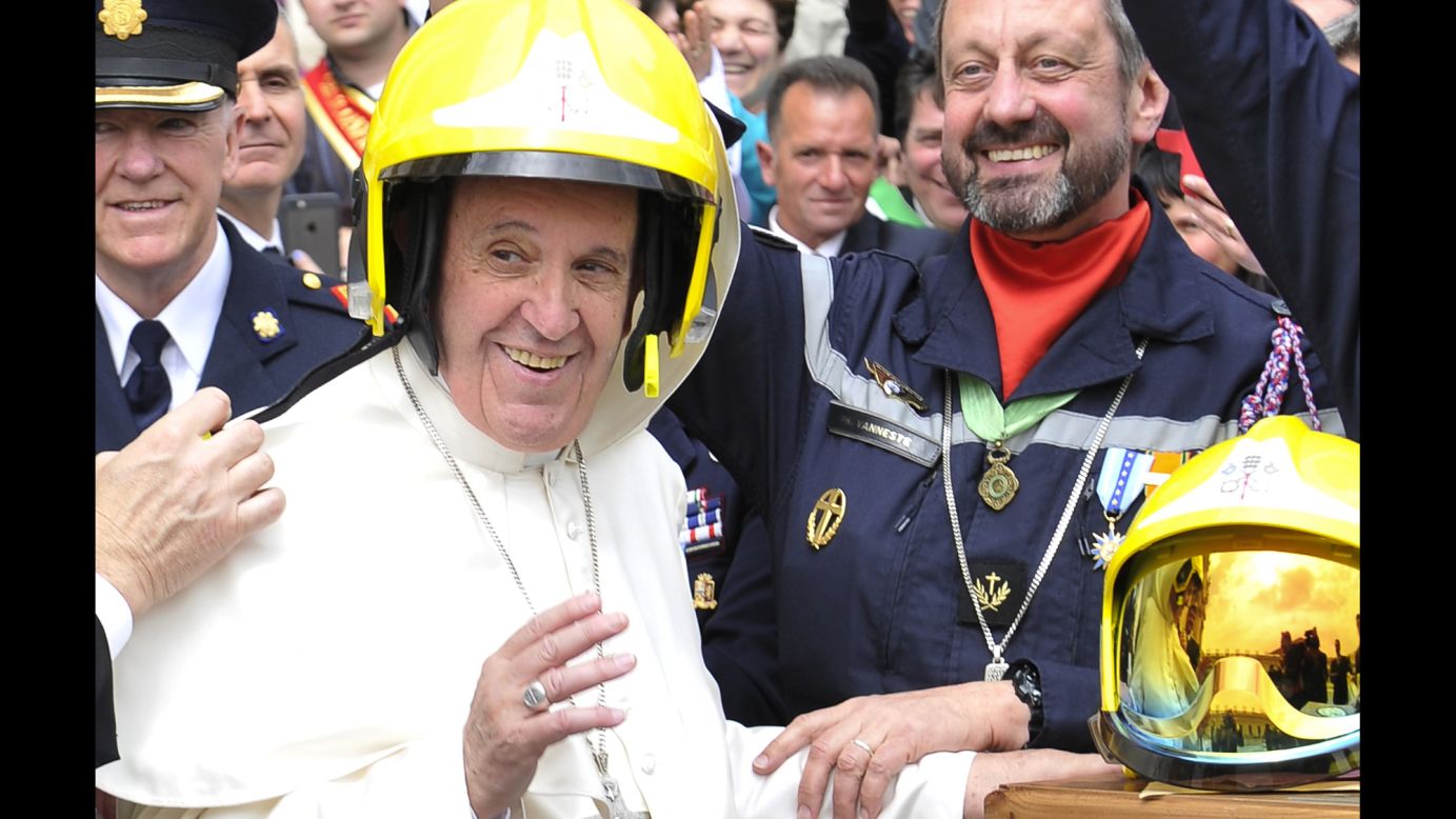 Pope Francis wears a firefighter's helmet as he meets with Vatican firefighters on Wednesday, April 13.