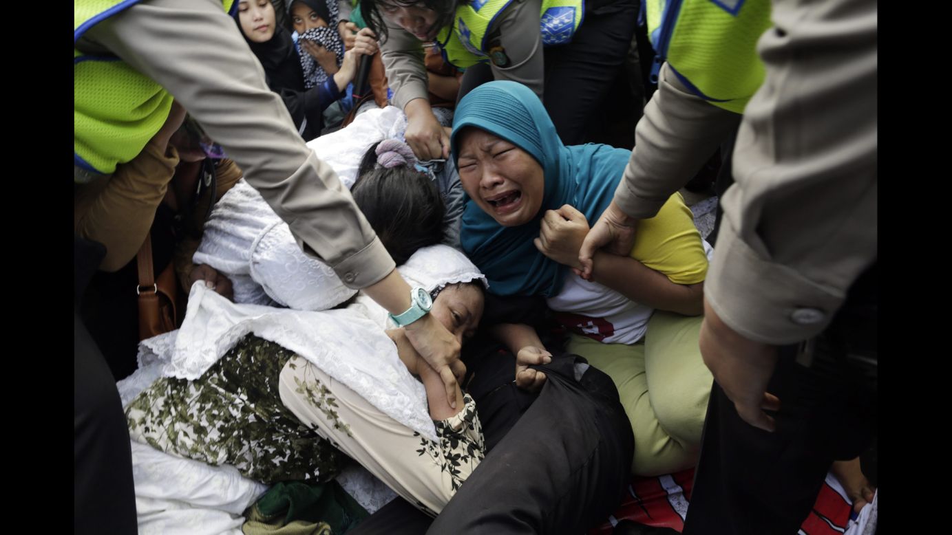 Security officers pull up protesting residents as houses were demolished in a slum area of Jakarta, Indonesia, on Monday, April 11. The government said the homes were illegally built in an area intended for commercial use. Hundreds of families accepted government terms to be moved to low-income housing.